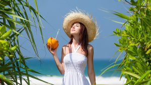girl drinking king coconut in beach